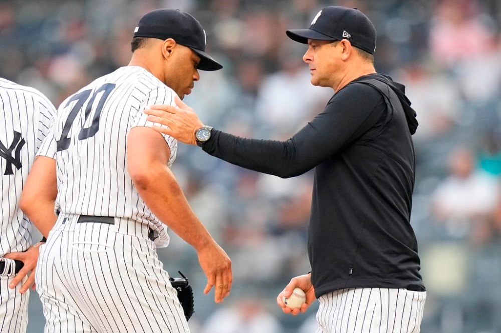 New York Yankees relief pitcher Jimmy Cordero (70) hands the ball to manager Aaron Boone as he leaves during the sixth inning in the first baseball game of a doubleheader against the Chicago White Sox, Thursday, June 8, 2023, in New York. (AP Photo/Frank Franklin II)