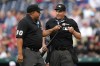 Umpires Adrian Johnson, left, and Quinn Wolcott inspect a knob on the bat of Cincinnati Reds' Elly De La Cruz in the second inning of a baseball game between the Reds and the Washington Nationals, Wednesday, July 5, 2023, in Washington. (AP Photo/Patrick Semansky)