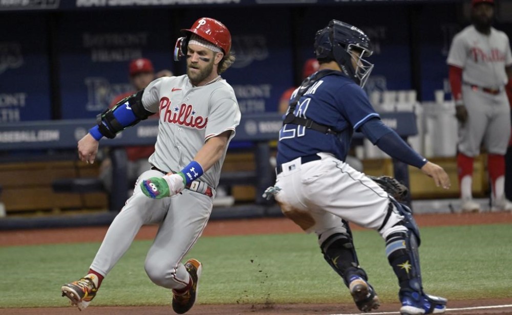Philadelphia Phillies' Bryce Harper, left, beats the throw to Tampa Bay Rays catcher Francisco Mejia to score on J.T. Realmuto's single during the third inning of a baseball game Wednesday, July 5, 2023, in St. Petersburg, Fla. (AP Photo/Steve Nesius)