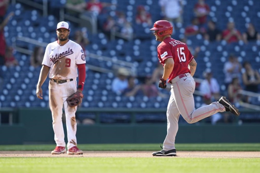 Cincinnati Reds' Nick Senzel, right, rounds the bases past Washington Nationals third baseman Jeimer Candelario after hitting a two-run home run in the 10th inning of a baseball game, Thursday, July 6, 2023, in Washington. Cincinnati won 5-4. (AP Photo/Patrick Semansky)