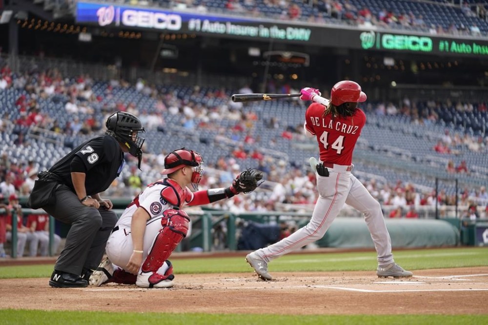 Cincinnati Reds' Elly De La Cruz singles in front of Washington Nationals catcher Riley Adams and umpire Manny Gonzalez in the second inning of a baseball game, Thursday, July 6, 2023, in Washington. (AP Photo/Patrick Semansky)
