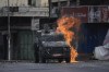 A Molotov cocktail thrown by a Palestinian protester explodes on an Israeli armored vehicle during clashes with Israeli security forces following a military raid in the West Bank city of Nablus, Friday, July 7, 2023. Palestinian health officials say two Palestinians were killed Friday by Israeli fire in the occupied West Bank, days after Israel concluded a major two-day offensive meant to crack down on militants. (AP Photo/Majdi Mohammed)