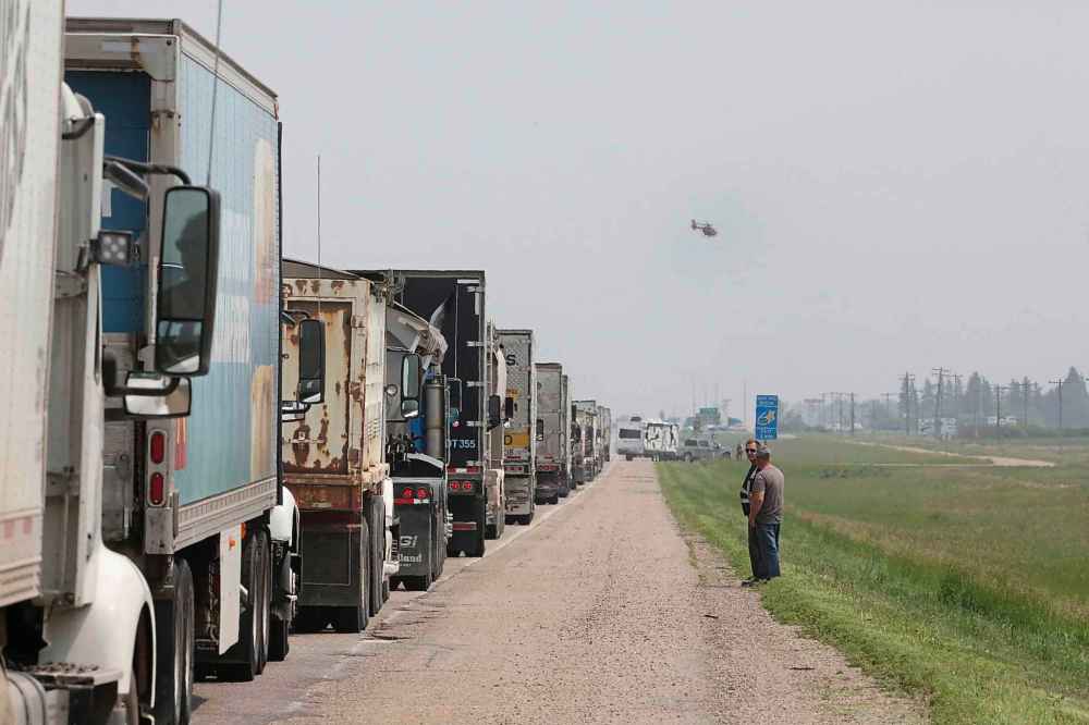A STARS Air Ambulance helicopter flies out from behind a line of semi trucks and vehicles along the eastbound lanes of the Trans-Canada Highway after the highway lanes were shut down. (Matt Goerzen / The Brandon Sun)