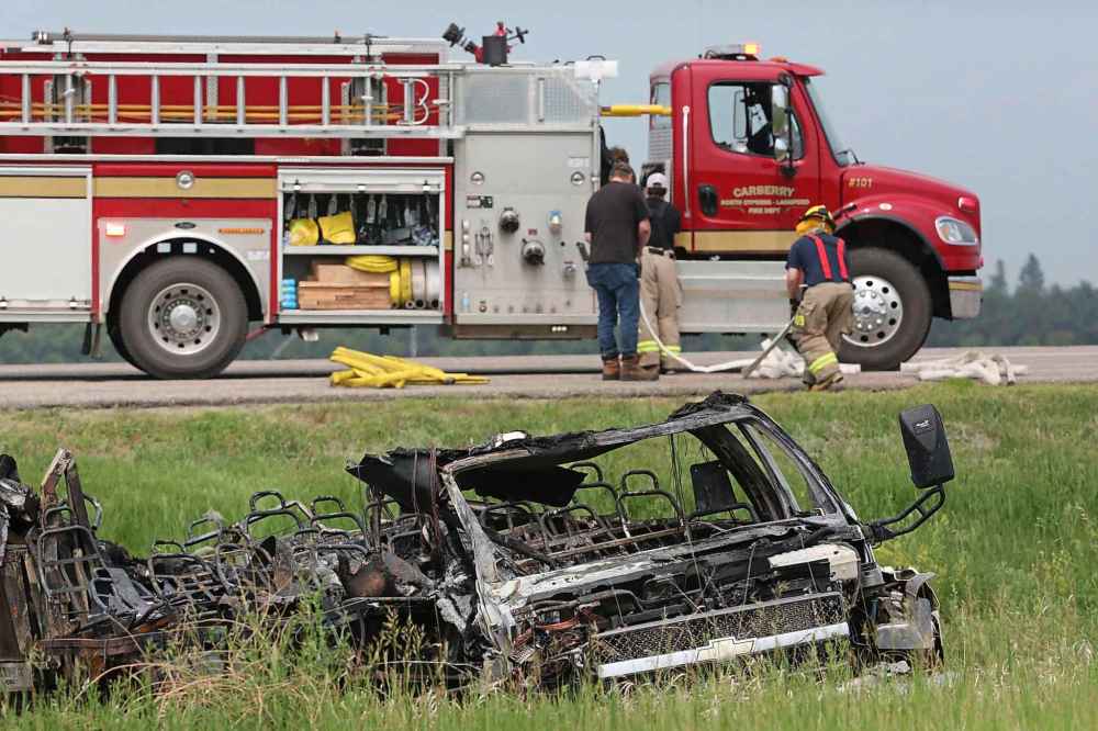 A burned out transport bus lies in the ditch on the south side of the Trans-Canada Highway. (Matt Goerzen / The Brandon Sun)