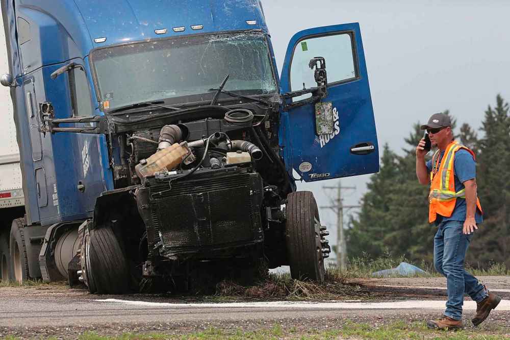 An emergency worker walks passed a semi truck that was involved in a deadly collision Thursday with a small bus carrying seniors at the corner of Highway 5 and the Trans-Canada Highway. The semi had the right of way, police say. (Matt Goerzen/The Brandon Sun)