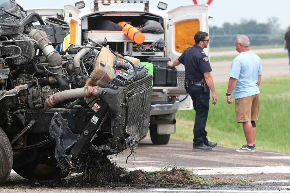 An RCMP officer speaks to an unidentified man near the semi-truck. (Matt Goerzen / The Brandon Sun)