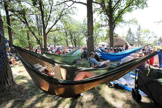 People lay in hammocks reading under clusters of trees to keep cool while attending the Winnipeg Folk Fest at Birds Hill Park in 2018. (Ruth Bonneville / Winnipeg Free Press files)