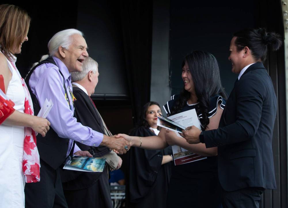 JESSICA LEE / WINNIPEG FREE PRESS
                                Angelica Revina and Victor Revina from the Philippines shake Elder Winston Wuttunee’s hand.