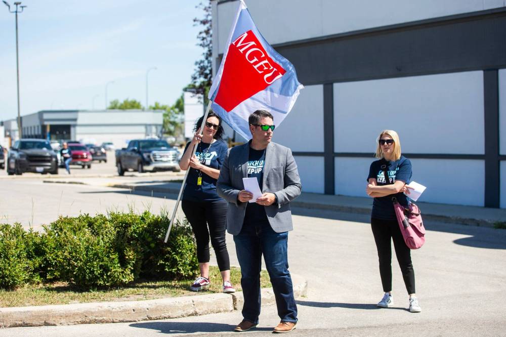 MIKAELA MACKENZIE / WINNIPEG FREE PRESS
MGEU President Kyle Ross (centre), Kristin Sutton (left), and Tracy Groenewegen distribute flyers in front of MLA James Teitsma’s office.