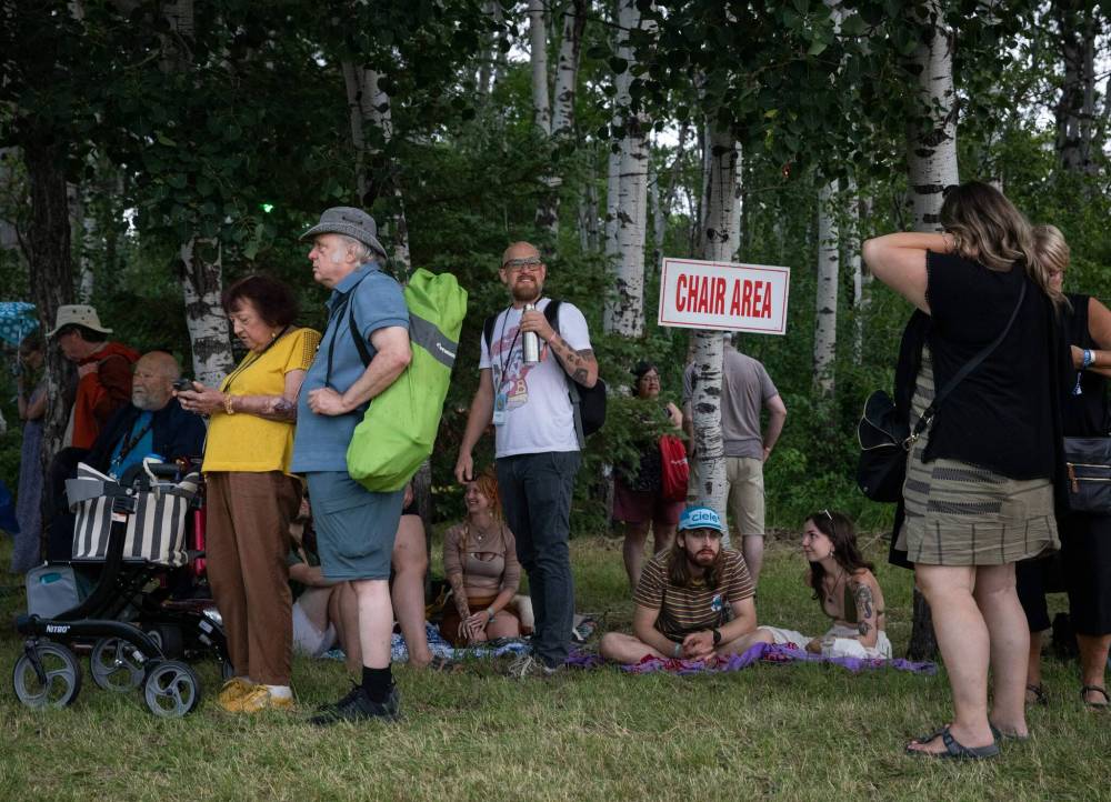 JESSICA LEE / WINNIPEG FREE PRESS
Festival attendees attempt to stay dry during Thursday’s opening-night downpour.