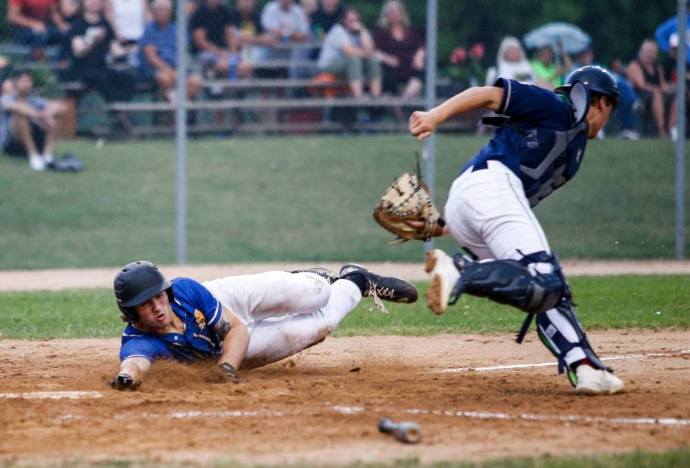 JOHN WOODS / WINNIPEG FREE PRESS
                                Ryder Duncan of the St. Boniface Legionaires dives for home Tuesday against the Elmwood Giants at Whittier Park.