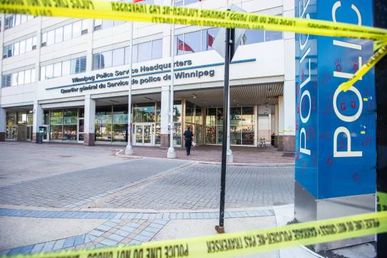 The front of the Winnipeg Police Service's downtown headquarters was taped off Wednesday, after a small group protested the arrest of an Indigenous man who's been calling for landfill searches. (Mikaela MacKenzie / Winnipeg Free Press)