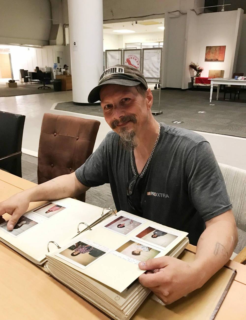 CAROL SANDERS / WINNIPEG FREE PRESS
BUILD team member Arron Lavis jokingly looks for his photo in the “book of shame” found at the former Bay building, a 1970s-era photo album of people banned for life from the store for shoplifting.