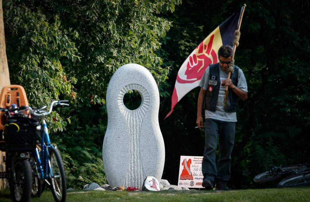 JOHN WOODS / WINNIPEG FREE PRESS
One of the dozens who participated in the rally at The Forks Sunday positions himself near a monument to missing and murdered Indigenous women and girls.