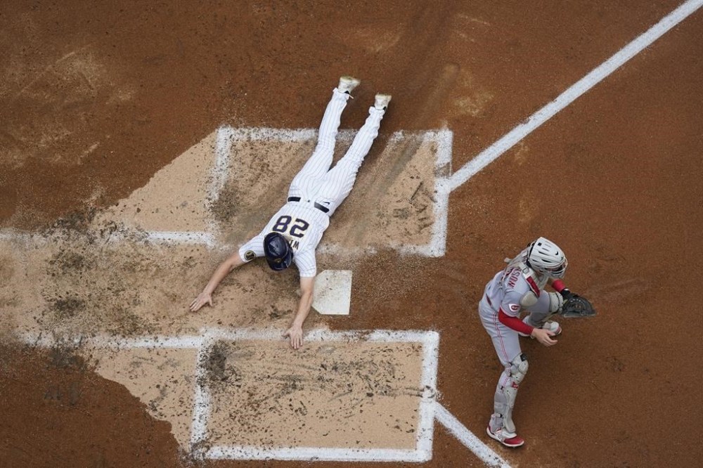 Milwaukee Brewers' Joey Wiemer scores past Cincinnati Reds catcher Tyler Stephenson during the third inning of a baseball game Saturday, July 8, 2023, in Milwaukee. (AP Photo/Morry Gash)