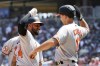 Baltimore Orioles' Aaron Hicks, front left, celebrates with teammates Colton Cowser (17) and Austin Hays, back left, after hitting a three-run home run against the Minnesota Twins in the fifth inning of a baseball game Sunday, July 9, 2023, in Minneapolis. (AP Photo/Andy Clayton-King)