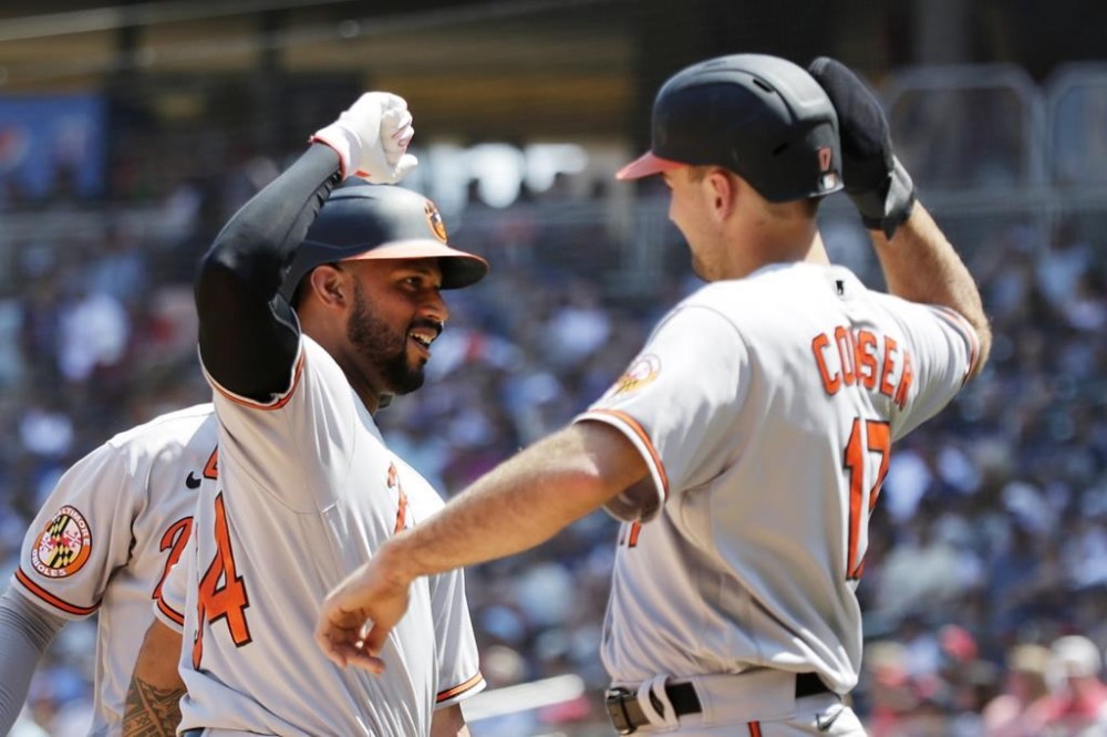 Baltimore Orioles' Aaron Hicks, front left, celebrates with teammates Colton Cowser (17) and Austin Hays, back left, after hitting a three-run home run against the Minnesota Twins in the fifth inning of a baseball game Sunday, July 9, 2023, in Minneapolis. (AP Photo/Andy Clayton-King)