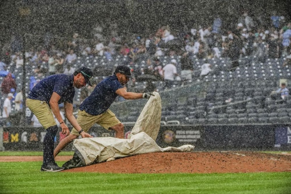 Yankees grounds crew John Salcedo, left, and Carlos Blanco cover the pitchers mount, during a rain delay during a baseball game between the New York Yankees and Chicago Cubs, Sunday, July 9, 2023, in New York. (AP Photo/Bebeto Matthews)