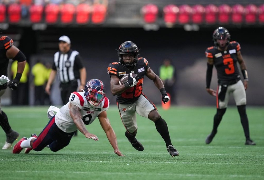 B.C. Lions' Shaun Shivers, centre, carries the ball past Montreal Alouettes' Jamal Davis II (9) during the second half of a CFL football game, in Vancouver, B.C., Sunday, July 9, 2023. THE CANADIAN PRESS/Darryl Dyck