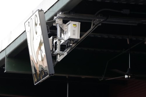 FILE - A radar device is mounted on the roof behind home plate at PeoplesBank Park during the third inning of the Atlantic League All-Star minor league baseball game in York, Pa., July 10, 2019. Major League Baseball started experimenting with robots calling balls and strikes in the independent Atlantic League in 2019 and used the computer at Low-A in 2021. (AP Photo/Julio Cortez, File)