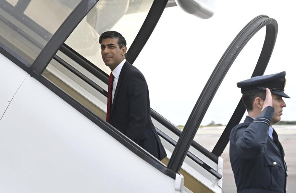 Britain's Prime Minister Rishi Sunak, left, boards a plane in London, Tuesday July 11, 2023 departing to Vilnius, Lithuania, where he is to attend a NATO Summit. (Paul Ellis/Pool Photo via AP)