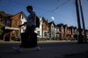 A person walks by a row of houses in Toronto on Tuesday July 12, 2022. Canada's banking regulator has launched consultations on proposed changes to mortgage guidelines to address risks related to borrowers with growing balances. THE CANADIAN PRESS/Cole Burston