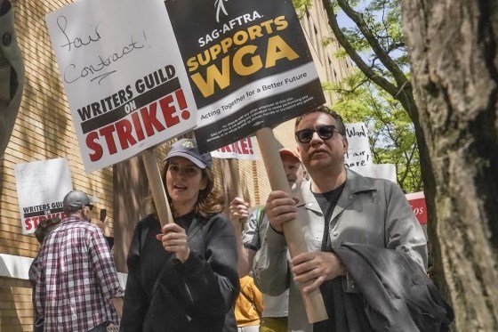 Actors and comedians Tina Fey, centre, and Fred Armisen, right, join striking members of the Writers Guild of America on the picket line in May. (Bebeto Matthews / The Associated Press files)