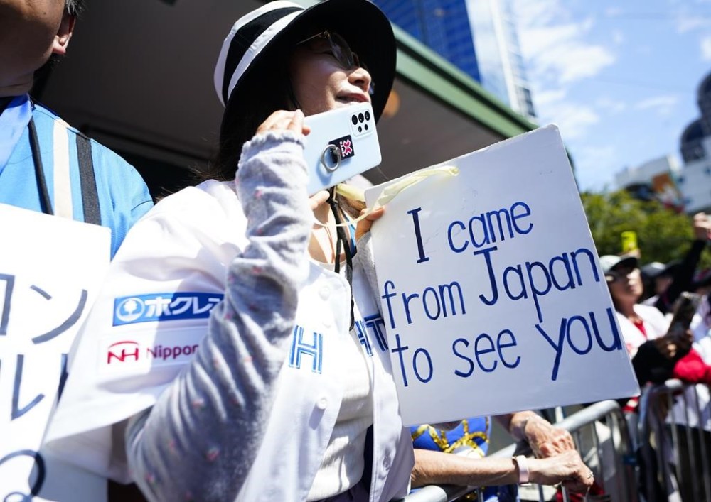 A fan holds a sign for American League's Shohei Ohtani, of the Los Angeles Angels, as he walks during the All-Star Game red carpet show, Tuesday, July 11, 2023, in Seattle. (AP Photo/Lindsey Wasson)