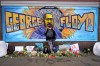 FILE - Damarra Atkins pays respect to George Floyd at a mural at George Floyd Square in Minneapolis, April 23, 2021. Minneapolis must enact police reforms in the wake of George Floyd's murder under a settlement agreement with the state Human Rights Department approved by a local judge Thursday, July 13, 2023. (AP Photo/Julio Cortez, File)