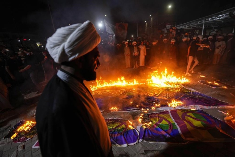 Supporters of Shiite Muslim leader Moqtada Sadr burn rainbow flags, during a demonstration in Sadr City, in response to the burning of Quran in Sweden, Baghdad, Iraq, Wednesday, July 12, 2023. (AP Photo/Hadi Mizban)