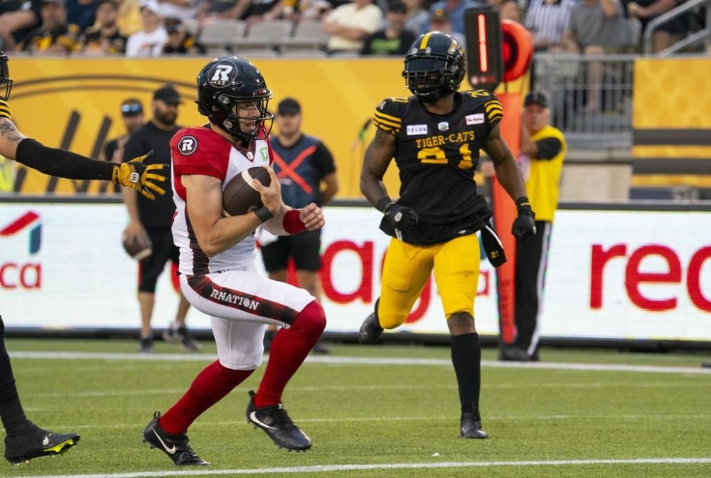 Ottawa Redblacks quarterback Dustin Crum (18) runs into the end zone for a touchdown during first half CFL football game action against the Hamilton Tiger-Cats in Hamilton, Ont. on Saturday, July 8, 2023. Crum is going to make history Saturday afternoon, whether he wins or loses. THE CANADIAN PRESS/Peter Power