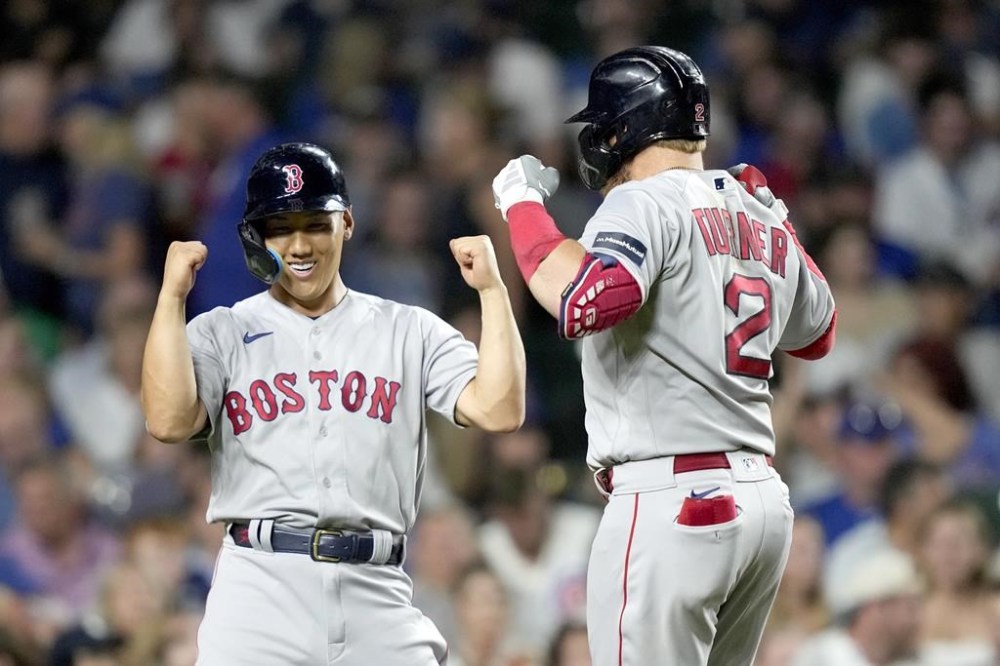 Boston Red Sox's Masataka Yoshida, left, celebrate with Justin Turner after Turner's two-run home run off Chicago Cubs relief pitcher Mark Leiter Jr. during the seventh inning of a baseball game Friday, July 14, 2023, in Chicago. (AP Photo/Charles Rex Arbogast)