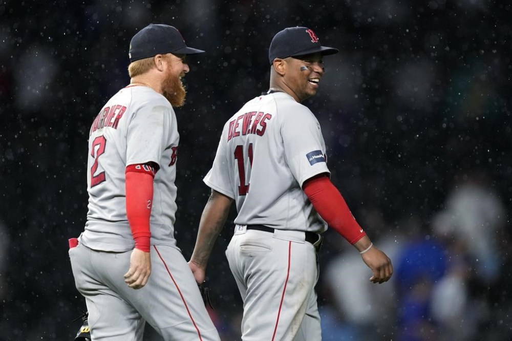 Boston Red Sox's Justin Turner and Rafael Devers smile after the team's 8-3 win over the Chicago Cubs in a baseball game Friday, July 14, 2023, in Chicago. (AP Photo/Charles Rex Arbogast)