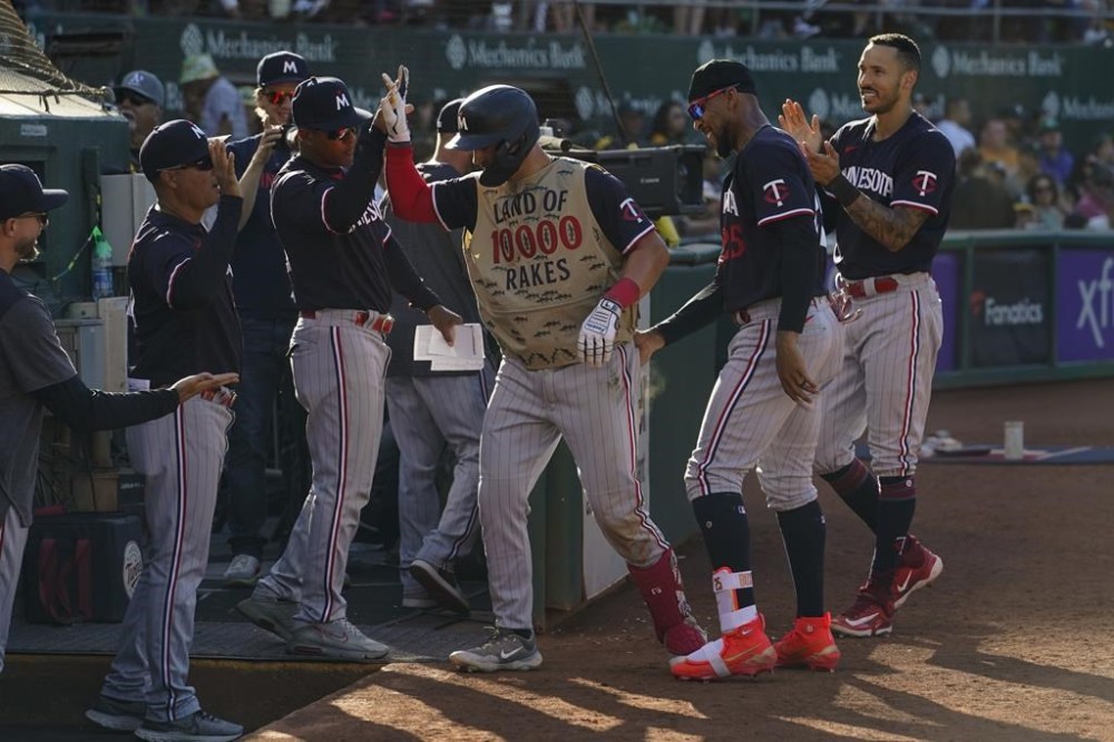 Minnesota Twins' Kyle Farmer, center, celebrates with teammates at the dugout after hitting a solo home run against the Oakland Athletics during the seventh inning of a baseball game Saturday, July 15, 2023, in Oakland, Calif. (AP Photo/Godofredo A. Vásquez)
