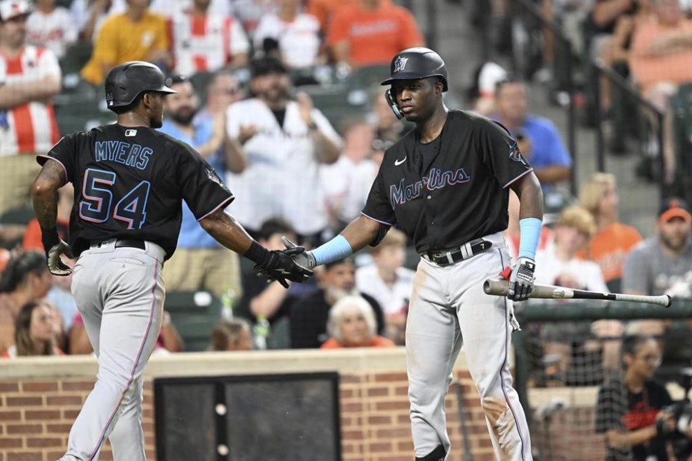 Miami Marlins' Dane Myers, left, is congratulated by Luis Arraez after scoring on a sacrifice fly by Bryan De La Cruz against the Baltimore Orioles during the fourth inning of a baseball game Saturday, July 15, 2023, in Baltimore. (AP Photo/Gail Burton)