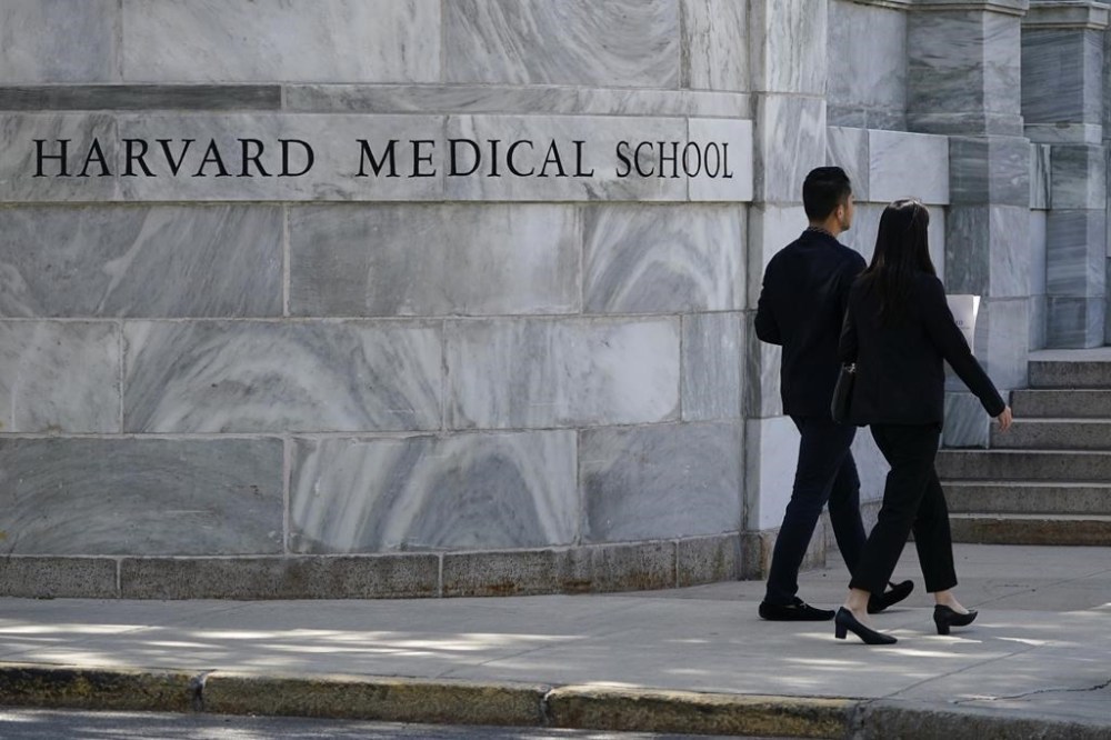 FILE - Pedestrians walk towards the Harvard Medical School, Aug. 18, 2022, in Boston. Federal investigators discovered a human remains trade with connections to Harvard Medical School and have arrested people in several states. According to prosecutors, the defendants were part of a nationwide network of people who bought and sold remains stolen from the medical school and an Arkansas mortuary. (AP Photo/Charles Krupa, File)