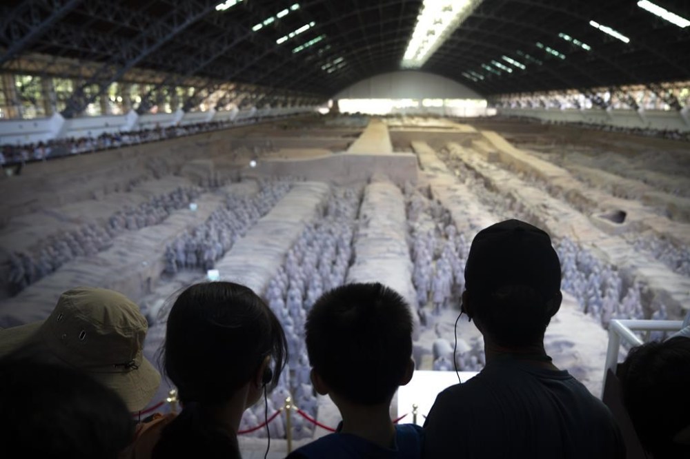 Visitors look at excavated figures on display at the Museum of Terracotta Warriors and Horses of Emperor Qin Shihuang in Xi