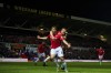 FILE - Wrexham's James Jones, left, celebrates with teammate Paul Mullin after scoring during the National League soccer match between Wrexham and Yeovil Town at the Racecourse Ground, Wrexham, Wales, Tuesday, April 18, 2023. Wrexham was down on its luck and languishing in the fifth tier of English soccer before being given the A-list treatment by Reynolds and co-owner Rob McElhenney. Now it is embarking on a U.S. tour this month and fans of the globally-streamed docuseries “Welcome to Wrexham” will get to see its unlikely stars in the flesh. (AP Photo/Jon Super, file)