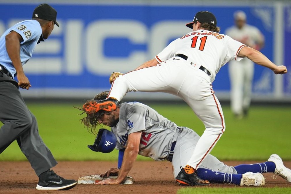 Los Angeles Dodgers' Jake Marisnick, bottom, is tagged out by Baltimore Orioles third baseman Jordan Westburg (11) while trying to steal second as umpire Edwin Moscoso during the eighth inning of a baseball game, Monday, July 17, 2023, in Baltimore. The Dodgers won 6-4. (AP Photo/Julio Cortez)
