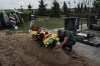 Cemetery worker Dmytro Pikulin places bouquets of flowers on the grave of Roman Shadlovskyi after a reburial service for him in Bucha, Ukraine, Tuesday, July 18, 2023. The Ukrainian Armed Forces veteran, who was initially buried in a mass grave as an unidentified victim after being killed last year by Russian troops, received a reburial Tuesday after a DNA test confirmed his identity. (AP Photo/Jae C. Hong)