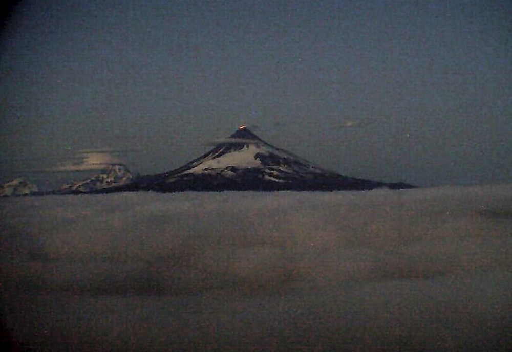 This web camera image provided by the U.S. Geological Survey shows glowing lava erupting within the summit crater of Shishaldin around 12:30 a.m. AKDT, Tuesday, July 18, 2023, as seen from the WTUG webcam located NW of the volcano. The ongoing eruption of a remote the volcano in Alaska's Aleutian Islands produced an ash cloud so large Tuesday warnings were sent to pilots about potentially dangerous conditions.(Alaska Volcano Observatory/U.S. Geological Survey via AP)