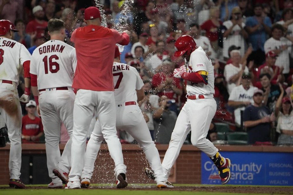 St. Louis Cardinals' Nolan Arenado, right, is congratulated by teammates as he arrives home after hitting a walk-off home run to defeat the Miami Marlins 5-2 during the 10th inning of a baseball game Tuesday, July 18, 2023, in St. Louis. (AP Photo/Jeff Roberson)