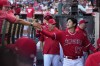 Los Angeles Angels' Shohei Ohtani, right, greets players in the dugout prior to a baseball game against the New York Yankees Tuesday, July 18, 2023, in Anaheim, Calif. (AP Photo/Mark J. Terrill)