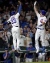 Chicago Cubs' Patrick Wisdom, right, celebrates his home run with third base coach Willie Harris in the seventh inning of a baseball game against the Washington Nationals Tuesday, July 18, 2023, in Chicago. (AP Photo/Charles Rex Arbogast)