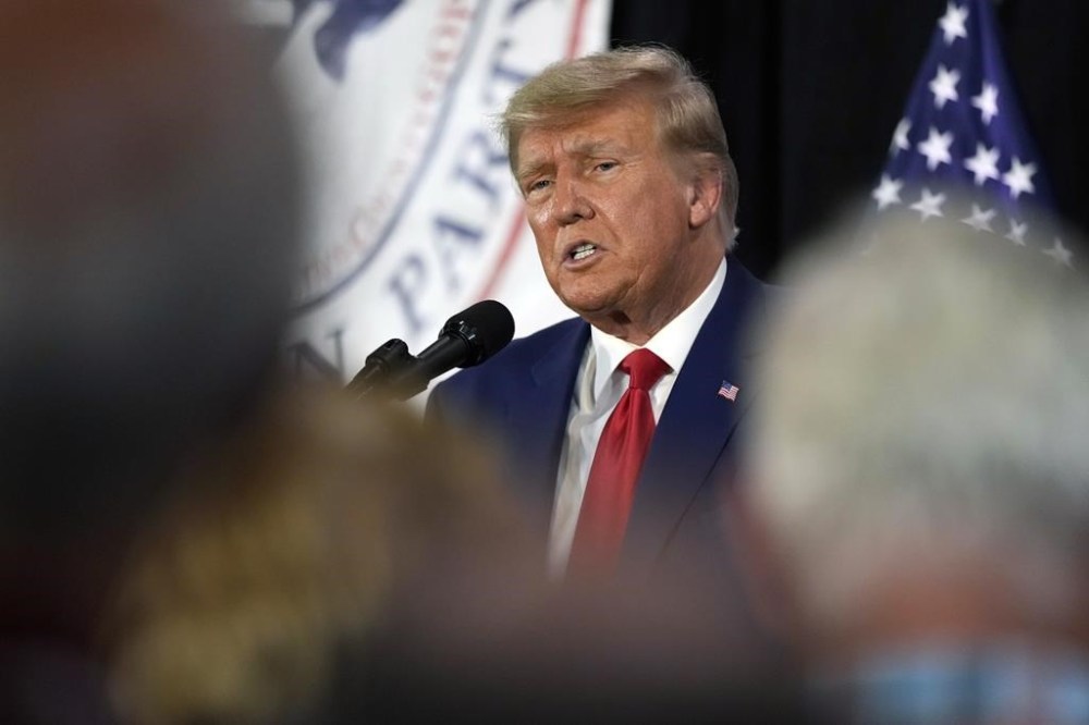 FILE - Former President Donald Trump visits with campaign volunteers at the Elks Lodge, July 18, 2023, in Cedar Rapids, Iowa. A target letter sent to Donald Trump suggests that a sprawling Justice Department investigation into efforts to overturn the 2020 elections is zeroing in on him. (AP Photo/Charlie Neibergall, File)