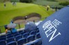 A spectator watches players on the 17th green during a practice round for the British Open Golf Championships at the Royal Liverpool Golf Club in Hoylake, England, Tuesday, July 18, 2023. The Open starts Thursday, July 20. (AP Photo/Jon Super)