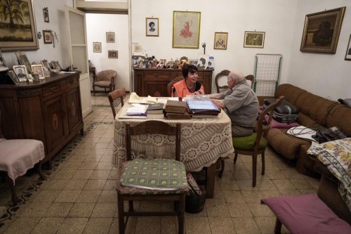 Sant'Egidio Catholic group volunteer Michela Tassani, left, chats with 98-year-old Armando Frajegari in his home, in Rome, Wednesday, July 19, 2023. As an intense heat wave with temperatures close to 40 degrees Celsius in many Italian cities is forcing elderly and fragile people to stay in their homes, Sant'Egidio volunteers check up on them providing company and helping in daily routines such as food shopping. (AP Photo/Andrew Medichini)