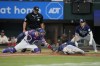 Texas Rangers catcher Jonah Heim tags out Tampa Bay Rays' Josh Lowe (15), who was attempting to score on a Manuel Margot double, as umpire Brock Ballou and Taylor Walls, rear right, look on in the second inning of a baseball game, Wednesday, July 19, 2023, in Arlington, Texas. (AP Photo/Tony Gutierrez)