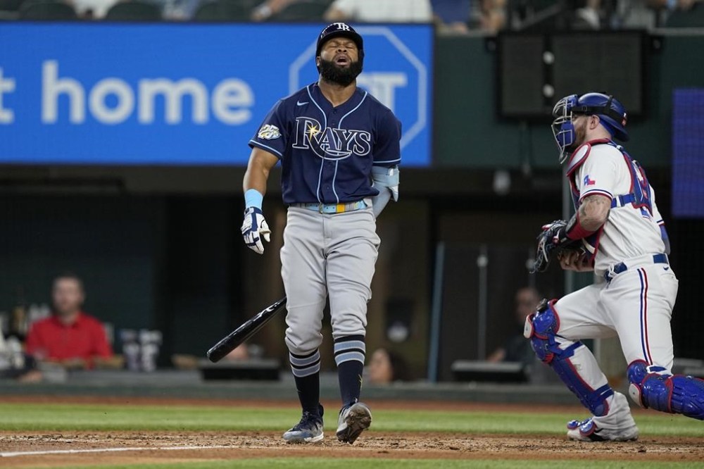 Tampa Bay Rays' Manuel Margot turns away from the plate after striking out as Texas Rangers catcher Jonah Heim stands up to head to the dugout in the fourth inning of a baseball game, Wednesday, July 19, 2023, in Arlington, Texas. (AP Photo/Tony Gutierrez)