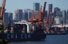 Gantry cranes sit idle as a container ship is docked at port during a work stoppage in Vancouver, on Wednesday, July 19, 2023. British Columbia port employers say the longshore workers union has given 72-hour notice of renewed strike action starting on Saturday morning. THE CANADIAN PRESS/Darryl Dyck